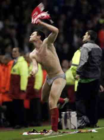 Liverpool's John Arne Riise throws his shirt to the crowd as he celebrates beating Chelsea in their Champions League semifinal second leg soccer match at Anfield, Liverpool May 3, 2005. 