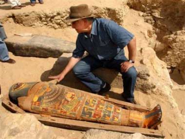 Zahi Hawass, chief of Egypt's Supreme Council of Antiquities, checks a brilliantly colored mummy dating back more than 2,300 years Tuesday May 3, 2005, at Egypt's Saqqara Pyramids complex south of Cairo. The unidentified mummy, from the 30th pharaonic dynasty, had been buried by sand in a 6 meter (20 feet) shaft. Hawass, said the mummy will undergo CT scanning before being put on display at a Saqqara museum. (AP