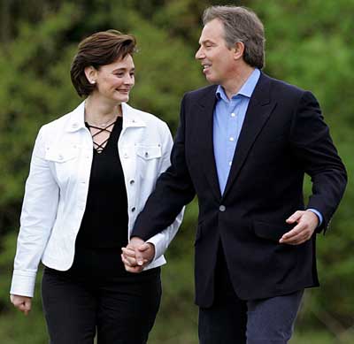 Britain's Prime Minister Tony Blair (R) walks across a field with his wife Cherie to cast his vote in the general election, at Trimdon Colliery in northern England, May 5, 2005. British voters went to the polls on Thursday, with surveys suggesting Prime Minister Tony Blair will win a third consecutive term despite anger over his decision to go to war in Iraq. 