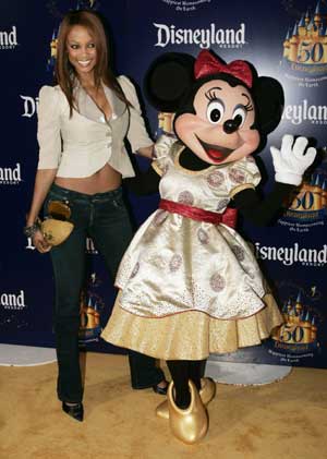 Supermodel Tyra Banks poses with Disney character Minnie Mouse during Disneyland's 50th anniversary party at the Disneyland theme park in Anaheim, California May 4, 2005. Walt Disney, founder of the Walt Disney Company and visionary behind the creation of Disneyland, opened the park on July 17, 1955. 