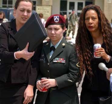 Army Pfc. Lynndie England, center, walks with Kathleen Johnson, right, as Kristine Didonato tries to cover her face after England's court martial was declared a mistrial at Ft. Hood, Texas, Wednesday, May, 4, 2005. (AP 