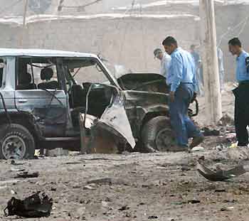Iraqi police examine the scene following a car bomb attack in southern Baghdad May 9, 2005. [Reuters]