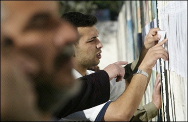 Palestinians search for their names before voting outside a polling station in the Bureij refugee camp that is situated inside the Gaza Strip. The Palestinian central elections commission began registering all voters whose names were not previously included on the electoral lists, ahead of legislative elections in July.(AFP/File