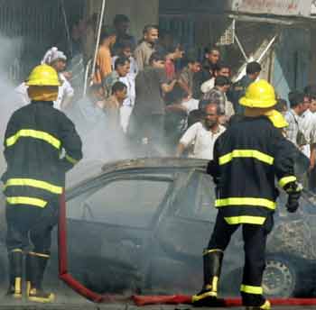 Iraqi civilians help firefighters to extinguish a fire caused by a suicide explosion in central Baghdad May, 10, 2005. [Reuters]