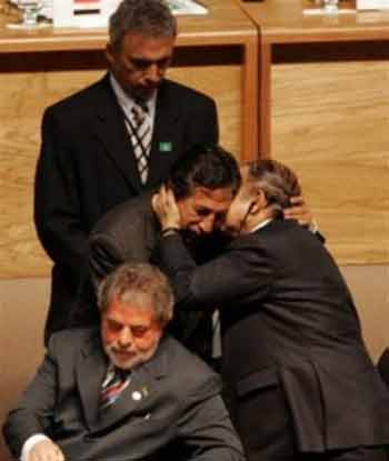 Algerian President Abdelaziz Bouteflika, left, kisses Peruvian President Alejandro Toledo, center, as Brazilian President Luiz Inacio Lula da Silva reads during the opening ceremony of the South American and Arab countries summit in Brasilia, Brazil, on Tuesday, May 10, 2005. (AP 