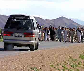 A passenger vehicle turns away from protestors armed with stones and sticks in Logar province, about 40 km (25 miles) southwest of Kabul May 12, 2005. Demonstrations spread in Afghanistan on Thursday over a report that U.S. interrogators at Guantanamo Bay had desecrated the Koran, and officials said three protesters were killed. [Reuters]