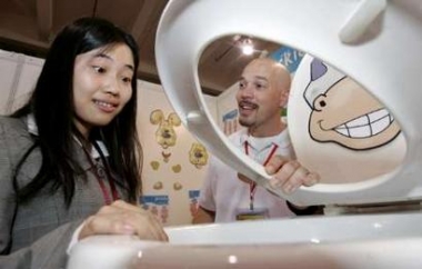 Joseph Lalicata (R) from New York, shows his child-friendly toilet to a Chinese buyer at the first World Toilet Expo in Shanghai, China May 10, 2005. The expo featured manufacturers from China and around the world with products ranging from novelty toilets to water saving devices. REUTERS