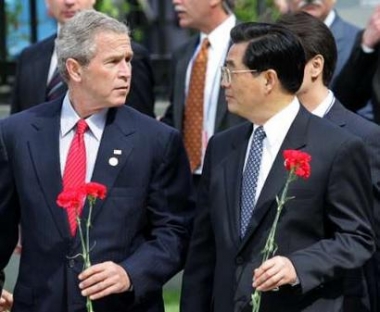 .S. President George W. Bush talks to Chinese President Hu Jintao (R) during a wreath laying ceremony at the Unknown Soldier Tomb outside the Kremlin wall in Moscow, May 9, 2005. 