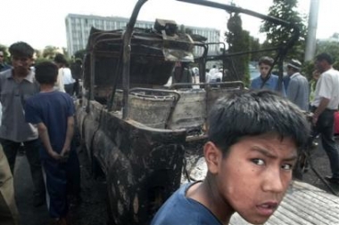 Local residents 
 stand at a burned car at the square outside the administration building in downtown Andijan, Uzbekistan, Friday, May 13, 2005. [AP]