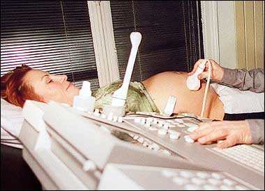 A pregnant woman receives routine prenatal screening. Couples desperate to produce a son could boost their chances if one or both of them switches to a 'masculine' profession such as engineering or accountancy, a report said.(AFP