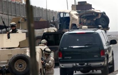 U.S. forces secure the area around a damaged Humvee, top-right, after a bomb rigged to a parked car exploded next to an American convoy by the al-Dora bridge in Baghdad Tuesday, May 24, 2005 killing three of the soldiers, according to a U.S. military spokesman. [AP]