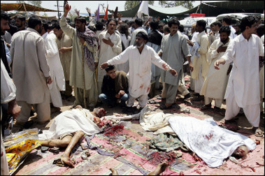 Pakistani Muslim devotees grieve over dead bodies following a bomb blast at a shrine in Islamabad. A suicide bomber blew himself up in the middle of a crowd of mainly Shiite Muslim worshippers at a Pakistani shrine, killing at least 14 people and injuring dozens.(AFP