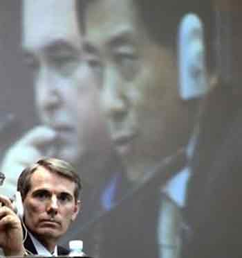 .S. Trade Representative Robert Portman, bottom, listens to the speech by China's Commerce Minister Bo Xilai, projected on a screen, during a joint press conference for officials from the 21 states and regions of the Asia-Pacific Economic Cooperation forum in Jeju island, south of Seoul, Friday, June 3, 2005.