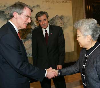 .S. Trade Representative Robert Portman (L) is greeted by Chinese Vice Premier Wu Yi, as U.S. Commerce Secretary Carlos Gutierrez (C) looks on in Beijing June 4, 2005. Gutierrez and Portman are in Beijing to discuss disputes over Chinese textiles exports and product piracy.
