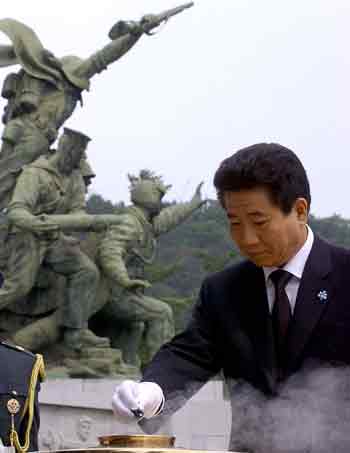 South Korean President Roh Moo-hyun pays his respects to Korean war victims by putting incense during a ceremony to mark Korean Memorial Day at the National Cemetery in Seoul June 6, 2005. Roh is due to meet President George W. Bush in Washington on Friday for talks on North Korea. REUTERS