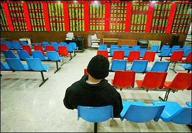 A man sits in front electronic stocks monitors in Shanghai. he future of China's deeply troubled stock markets went from bad to worse this week, slumping to fresh eight-year lows as regulators' plans to solve the overhang of non-tradable government-owned shares heightened fears more losses lie ahead.(AFP