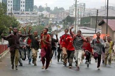 Youths carrying stones run on the road to the Addis Ababa city hall in Ethiopia June 8, 2005. The Ethiopian government confirmed several deaths on June 8 in violence it blamed on looting it said was fomented by opposition parties protesting disputed election results. (Andrew Heavens/Reuters) 