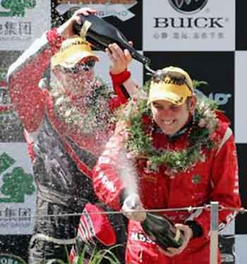 Australia's Todd Kelly (R) of the Holden Racing team, celebrates his overall victory in the V8 Supercar race, with second-placed driver Australia's Steven Richards (L) from Team Perkins, at the Shanghai International Circuit in Shanghai, China June 12, 2005. Kelly won 2 of the 3 races at the event to become the overall winner of the Shanghai round. REUTERS