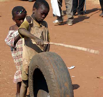 A Zambian boy plays with a used tyre in Livingstone, Zambia, June 11, 2005. The world's wealthiest countries clinched a deal on Saturday to wipe out more than $40 billion of impoverished nations' debts in a drive to free Africa from hunger and disease. [Reuters]