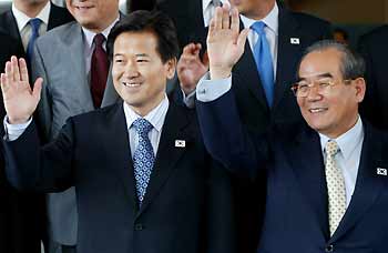 South Korea's Unification Minister Chung Dong-young (L) and his predecessor Lim Dong-won, who played a major role in organising the inter-Korean summit in June 2000, wave as they leave for North Korea in Seoul June 14, 2005. South Korea sent a 40-member government delegation, led by Chung, to Pyongyang to attend ceremonies to mark the anniversary of the historic 2000 inter-Korea summit in events spread over four days.