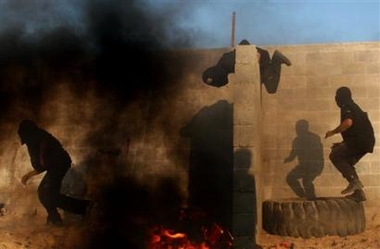 Militants of the Al-Aqsa Martyrs Brigades, a militia group linked to the ruling Fatah movement, practice jumping a wall during a training exercise in Gaza City, Friday June 10, 2005. 