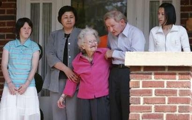 Charles Jenkins, a U.S. soldier who deserted his Army unit 40 years ago and fled to North Korea (2nd R) whispers to his 91-year-old mother Patty Casper (C) on the porch of his sister's home in Weldon, North Carolina June 14, 2005. With Jenkins are his daughter Brinda (L), wife Hitomi Soga (2nd L) and daughter Mika (R). REUTERS