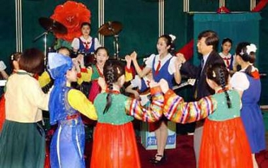 South Korean representatives (2nd R and L) from educational civic groups dance with North Korean students as they visit a middle school in the North Korean capital of Pyongyang June 15, 2005.