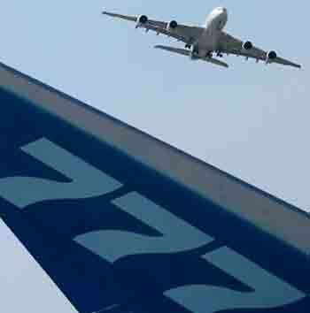 The tail of a Boeing 777 plane is seen as an Airbus A380, the world's biggest airliner, flies in the background at the Paris Air Show in Le Bourget, near Paris, June 14, 2005.