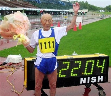 Kozo Haraguchi, a 95-year-old Japanese, waves with a bouquet of flowers after setting a world record in 100 meters track for men aged 95-99 at an athletic event in Miyazaki, southern Japan, Sunday, June 19, 2005. Haraguchi ran in time of 22.04 seconds to break the previous world record of 24.01. (AP