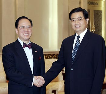 Chinese President Hu Jintao (R) shakes hands with newly sworn-in Chief Executive of Hong Kong Special Administrative Region Donald Tsang Yam-kuen during their meeting in the Great Hall of the People in Beijing June 24, 2005. (Xinhua 