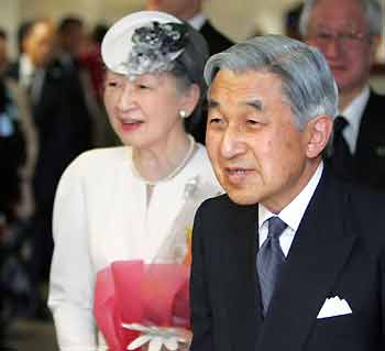 Japanese Emperor Akihito (R) and Empress Michiko smile as they are welcomed on arrival at the Saipan international airport June 27, 2005. Akihito flew in to the U.S. territory to mourn those who died in World War II, 60 years after the end of a conflict that still haunts his country's ties with its Asian neighbors. [Reuters]