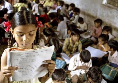 A school girl reads her book inside her class at a government-run school in village Kurana on the outskirts of Bhopal in this picture taken August 24, 2004. India should invest more in education to maintain and deepen its niche in information technology and high-skilled labor, the World Bank said on Tuesday. REUTERS