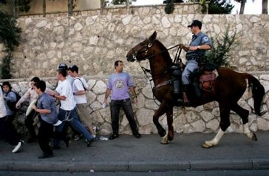 An Israeli mounted police officer rides towards anti-disengagement protesters during a demonstration aimed at blocking traffic in the ultra-orthodox Mea Shearim neighborhood in Jerusalem, Wednesday, June 29, 2005.