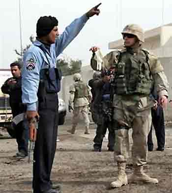 An Iraqi police officer and an U.S. soldier argue on collecting remains of the suicide bomber after a suicide attack at a polling station when a bomber blew up himself, one policeman and two Iraqi soldiers, in Baghdad, in this Jan. 30, 2005 file photo. 