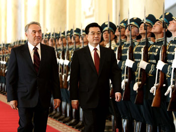 Kazakh President Nursultan Nazarbayev accompanies visiting Chinese President to review the guard of honor in Astana July 3, 2005. Hu arrived in the Kazakh capital Sunday for a state visit to the Central Asian nation and a summit of the Shanghai Cooperation Organization (SCO). [Xinhua]
