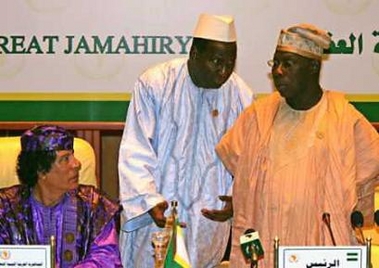 Libyan leader Muammar Gaddafi (L) looks on as Nigerian President Olusegun Obasanjo (R) talks to African Union Secretary-General Alpha Oumar Konare during their meeting in Sirte, Libya July 4, 2005. 
