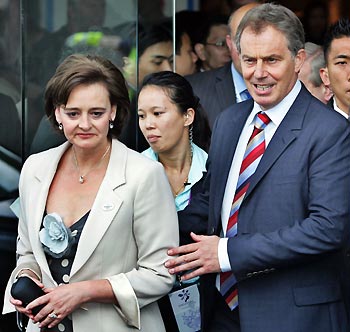 Britain's Prime Minister Tony Blair (R) and wife Cherie (L) leave a hotel in Singapore July 4, 2005. Blair is in the city to support London's bid to host the 2012 Summer Olympic Games. Paris, London, Madrid, New York City and Moscow are competing to win the right to host the games in a vote which will be held on July 6 in Singapore. [Reuters]