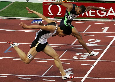 Xiang Liu of China (L) crosses the finish line next to Terrence Trammel of the U.S. in the men's 110-meter hurdles race at the IAAF Grand Prix athletics meet in Lausanne, Switzerland, July 5, 2005. Liu and Trammel both clocked 13.05 seconds to finish first and second respectively. [Reuters]