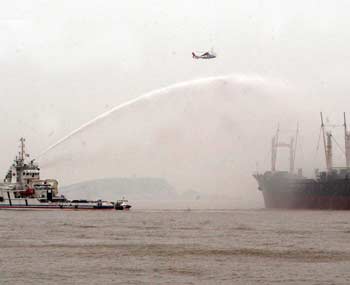 A rescue vessel tries to put out a blaze on another ship during during the "2005 East China Sea United Search and Rescue Drill" in seas off China's financial centre Shanghai July 7, 2005. [newsphoto]