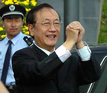 Taiwan New Party's Chairman Yok Mu-ming makes a traditional Chinese greeting to wellwishers during his visit to Dalian Economic and Development Zone in the coastal city of Dalian, Northeast China's Liaoning Province, July 9, 2005. [Xinhua]