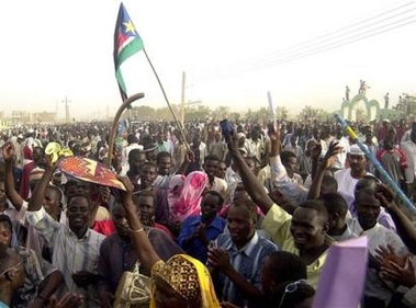 Western Sudanese, one waving a flag of the Sudan People's Liberation Movement celebrate the return of former rebel leader John Garang to the capital of Khartoum, Friday July 8, 2005. Garang made a triumphant return to Khartoum on Friday, greeted the president and a hundreds of thousands of supporters hopeful for a new era after Africa's longest civil war. (AP
