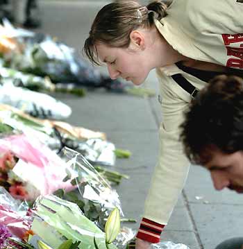 A man leaves flowers in memory of the victims of the bomb blast at King's Cross in London.