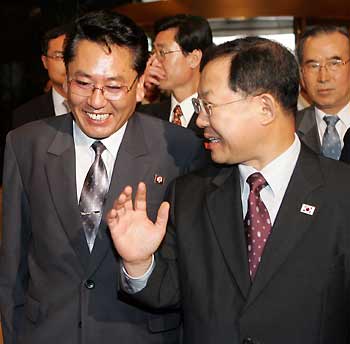 The head of North Korean delegation, Choe Yong-gon (L), Deputy Minister of Construction and Building Material Industries, chats with South Korean Vice Finance Minister Bahk Byong-won, as he arrives at the venue of inter-Korean trade talks in Seoul July 9, 2005.