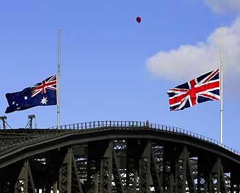 A red balloon floats past the Union Jack (R) and the Australian Flag on top of the Sydney Harbour Bridge which fly at half mast as a mark of respect for people killed in the London train and bus bombings, July 9, 2005. 