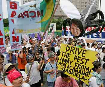 Filipino protesters demonstrate against Philippine President Gloria Macapagal Arroyo along Manila's Makati financial district July 13, 2005. A huge protest promised by Philippine opposition groups began slowly under cloudy skies on Wednesday, as investors and analysts watched the crowd's size as a barometer of President Arroyo's future. [Reuters]