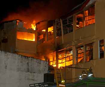 Costa Rican firemen fight a fire at the Calderon Guardia hospital in San Jose, July 12, 2005. Eighteen people, mostly patients, were killed by a fire that broke out at the neurosurgery and intensive care floors of one of Costa Rica's main hospitals on Tuesday, a Red Cross official said. [Reuters]
