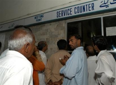 Relatives and family members of passengers travelling on Karachi-Lahore bound passenger train, look for information about accident at Karachi railway station, Wednesday, July 13, 2005 in Pakistan.