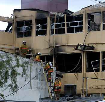 Costa Rican fire fighters work at the gutted Calderon Guardia hospital in San Jose July 12, 2005. [Reuters]
