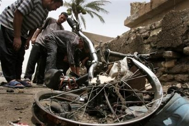 Iraqis sift through the scene of a suicide car bomb attack in Baghdad, Iraq Wednesday, July 13, 2005. 