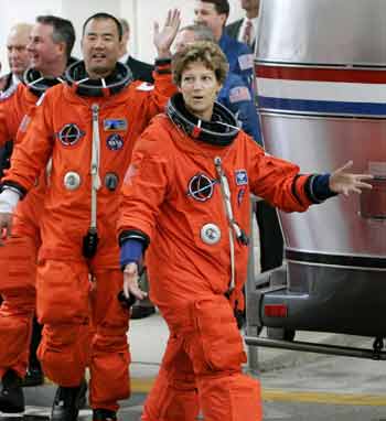 Space shuttle Discovery Commander Eileen Collins (R) leads crew members Stephen Robinson (L) and Soichi Noguchi of Japan as the crew departs their quarters for launch pad 39B at Kennedy Space Center in Cape Canaveral, Florida, July 13, 2005. The crew hopes to depart for an 11-day mission to the International Space Station. [Reuters]